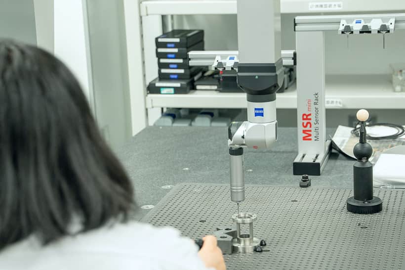 制服を着た社員同士が資料を見ながら話し合う様子
