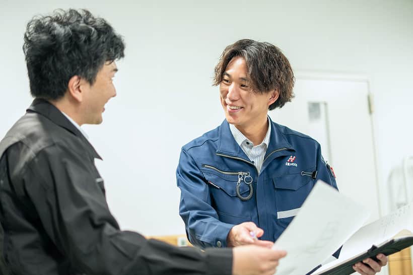 会議室で資料を見ながら談笑する社員たち