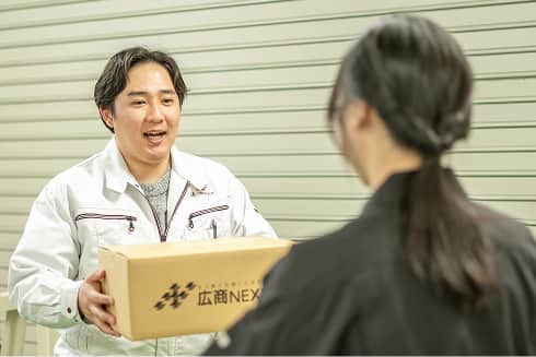 倉庫で荷物を手渡す社員